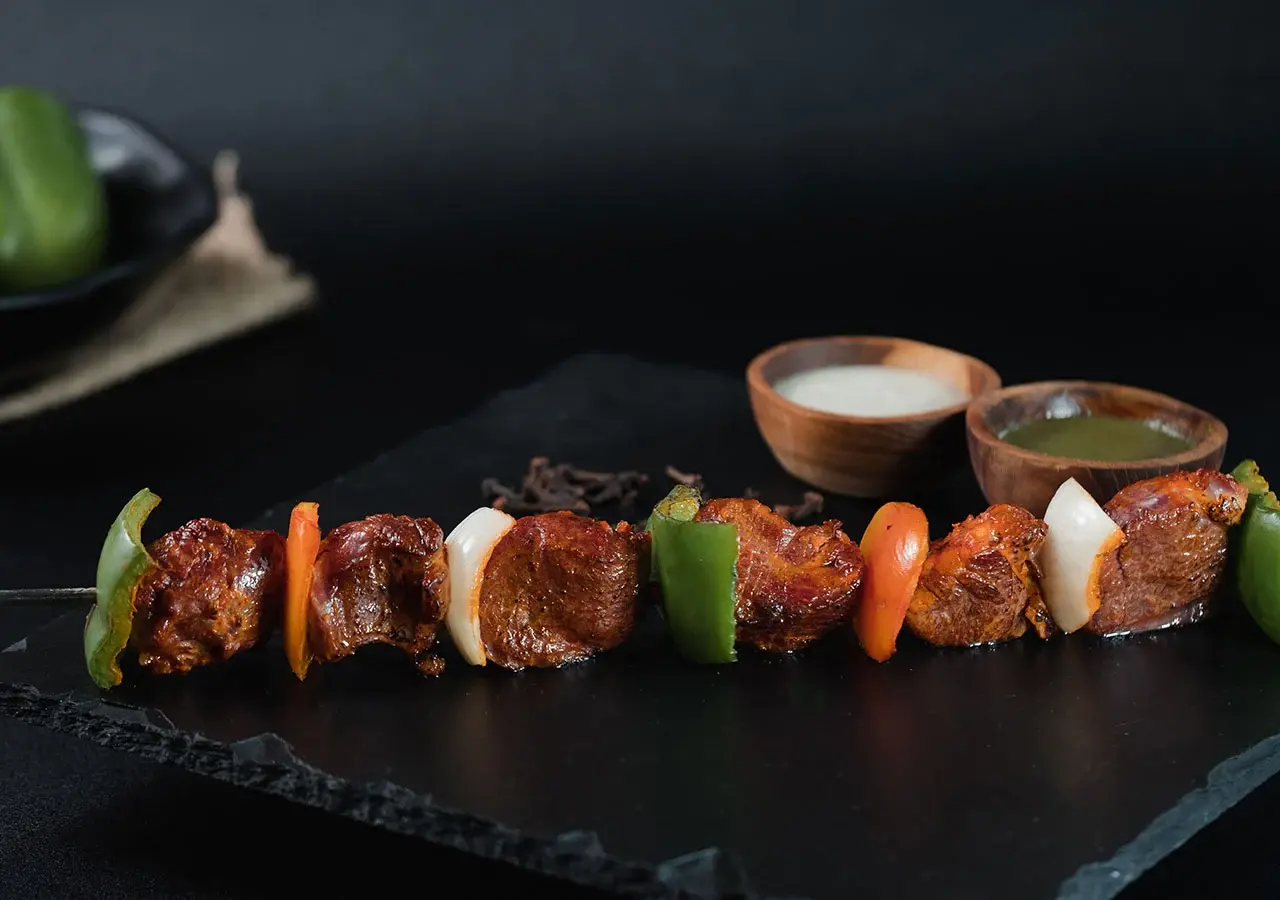 Boti Kebab on a skewer on a black stone plate at Queen’s of India Ubud Bali